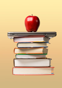 red apple on top of laptop and pile of books